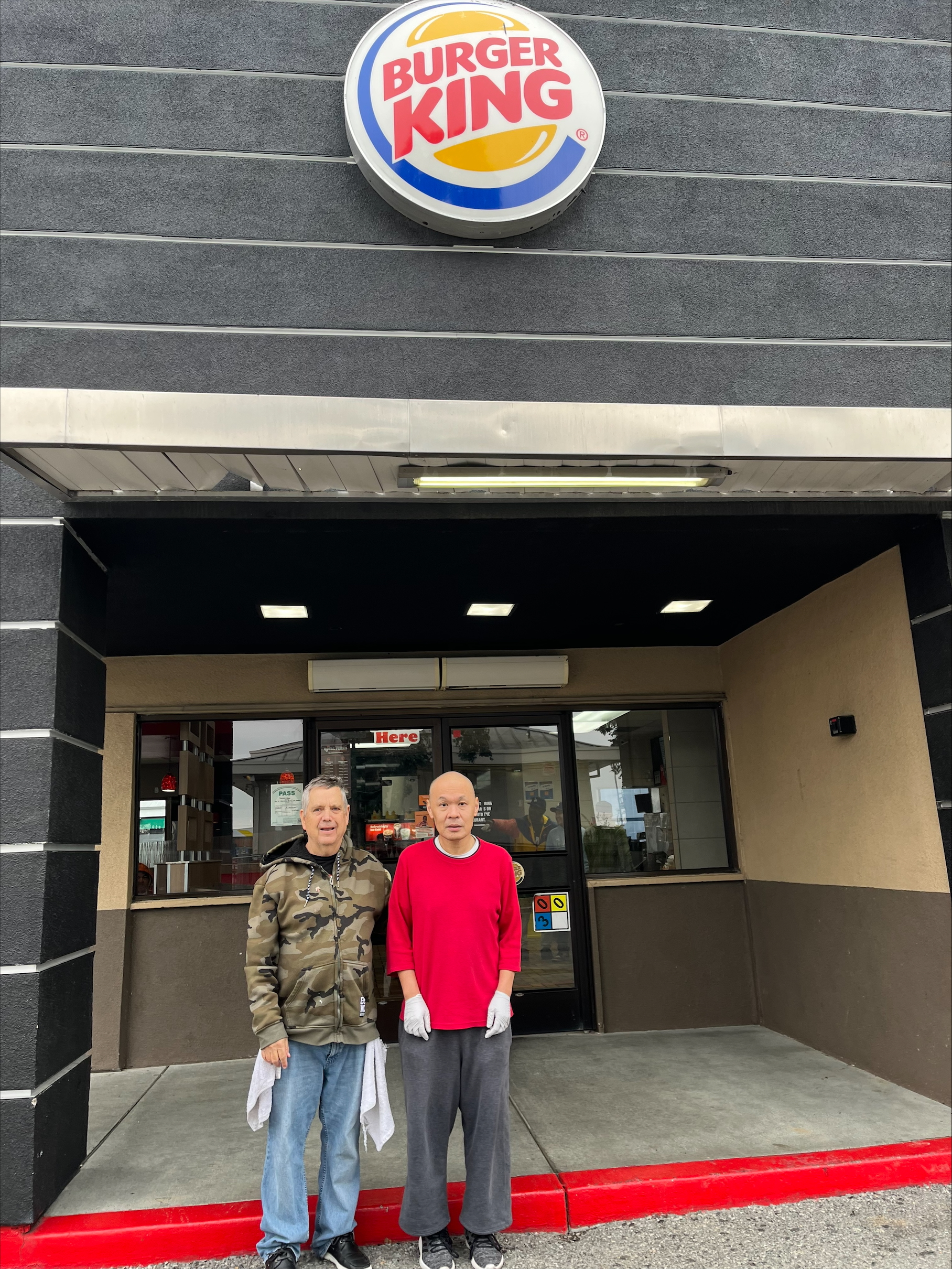 Two man standing in front of Burger King