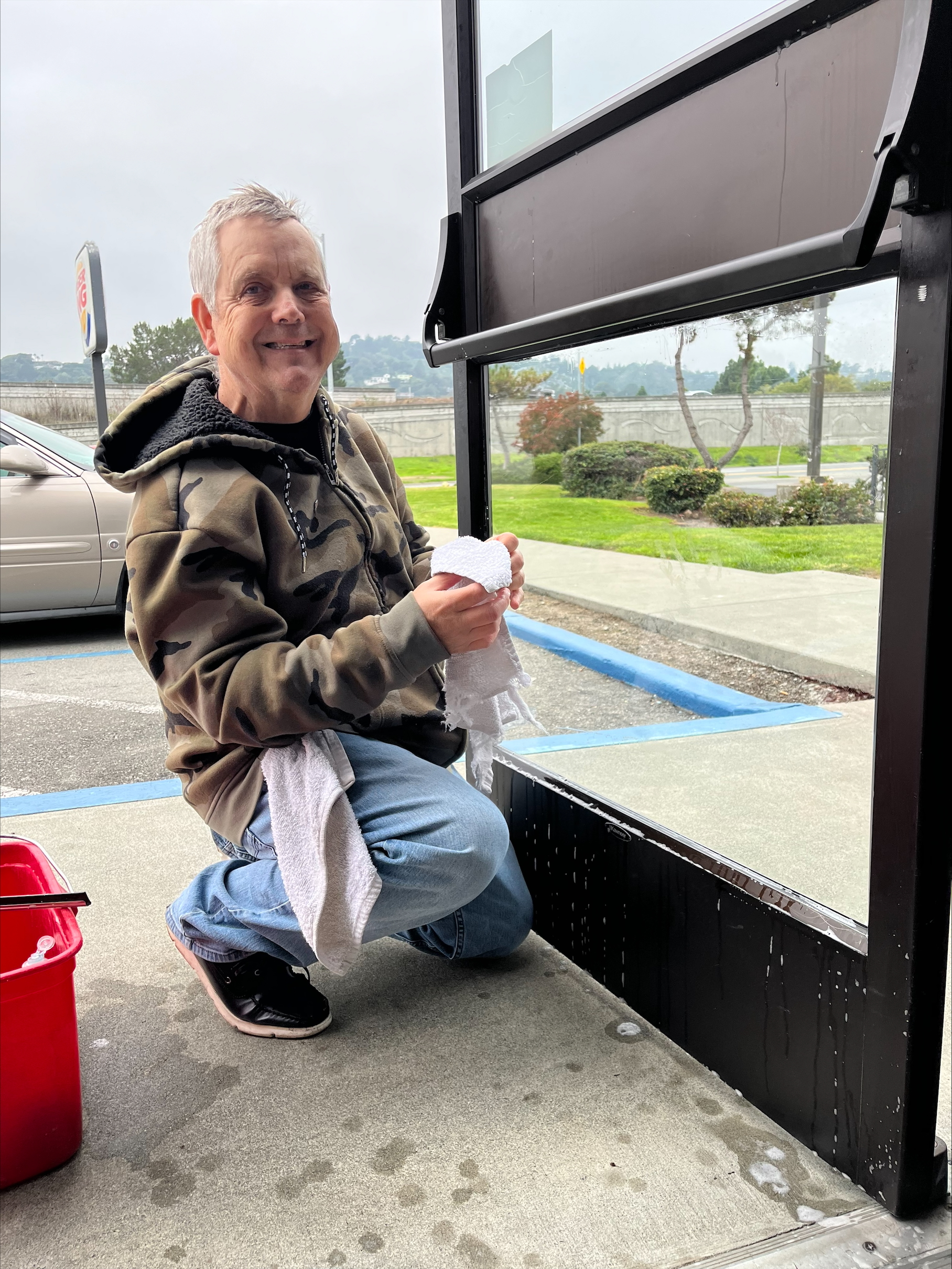 Smiling man cleaning windows
